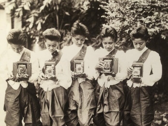 A group of noblewomen poses with cameras, around 1897.
