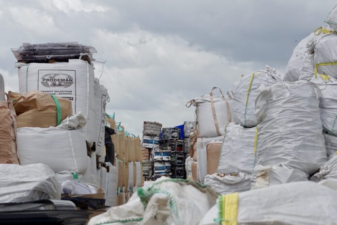 Piles of garbage on June 13 tower over a Pathum Thani facility accused of illegally importing waste.