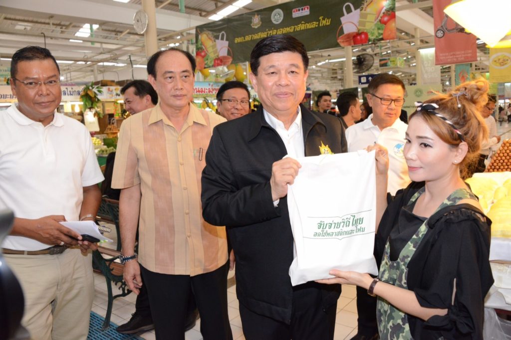 Minister Gen. Surasak Kanjanarat poses with a cloth bag he said the market would switch to using at a news conference last Thursday.