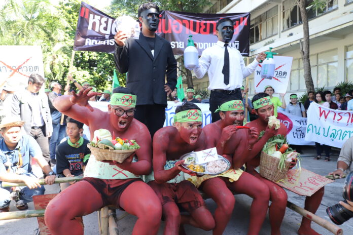 Protesters stage a performance against the use of a toxic weed killer Tuesday near the Government House.