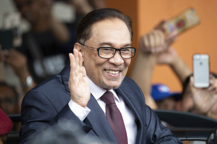 Prominent Malaysian politicin Anwar Ibrahim waves to supporters as he leaves a hospital Saturday in Kuala Lumpur. Photo: Vincent Thian / Associated Press