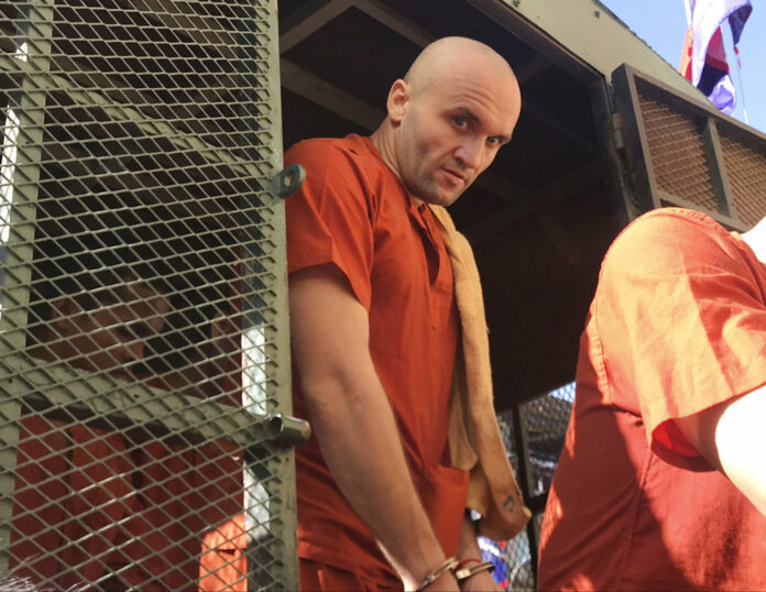 David Noel Catry of Belgium gets off form a prison truck upon its arrival Friday at the Phnom Penh Municipal Court in Phnom Penh. Photo: Lok Samret / Associated Press