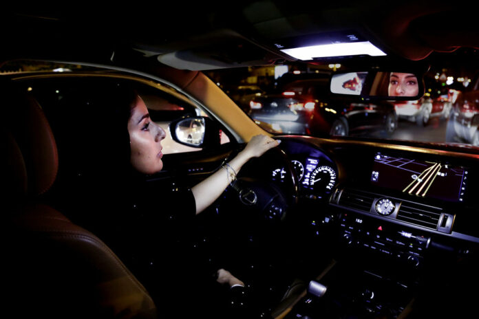 Hessah al-Ajaji driver her car down the capital's busy Tahlia Street after midnight for the first time Sunday in Riyadh, Saudi Arabia. Photo: Nariman El-Mofty / Associated Press