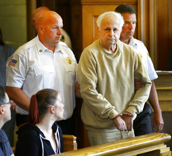 Former Milton Academy teacher Reynold Buono, 72, is escorted into Norfolk County Superior Court, on Wednesday in Dedham, Massachusetts. Photo: Greg Derr / The Quincy Patriot Ledger