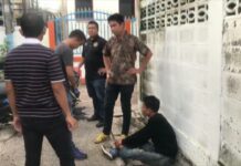 Ex-Con Accused of Stealing Temple Donations Dejdamrong Jomthank sits on the floor Tuesday during a police reenactment at Wat Nong Waeng in Khon Kaen.