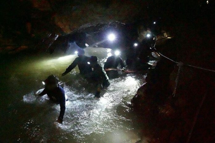 Rescue workers wading through floodwater inside Tham Luang Nang Non complex on Saturday (Photo provided by the authorities)