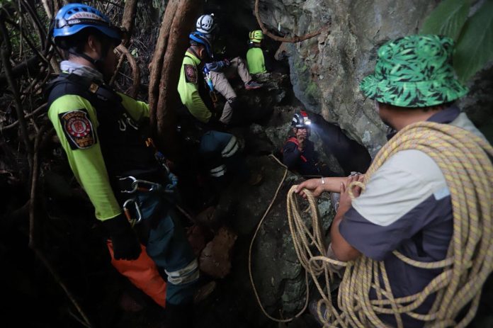 Explorers continue to search the mountain for a 'chimney' that could lead to the cavern where the 12 young footballers and their coach are trapped.