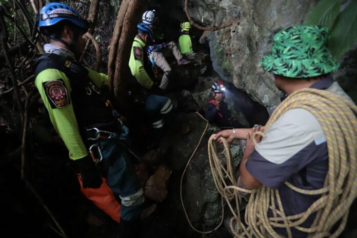 Explorers continue to search the mountain for a 'chimney' that could lead to the cavern where the 12 young footballers and their coach are trapped.