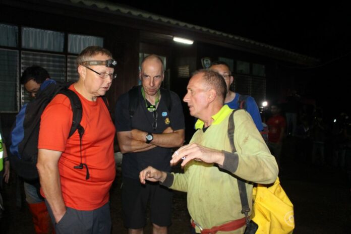 Caving expert Robert Harper, at left, and rescue diver Richard William Stanton, at middle, outside the Tham Luang Nang Non cave complex in Chiang Rai province.