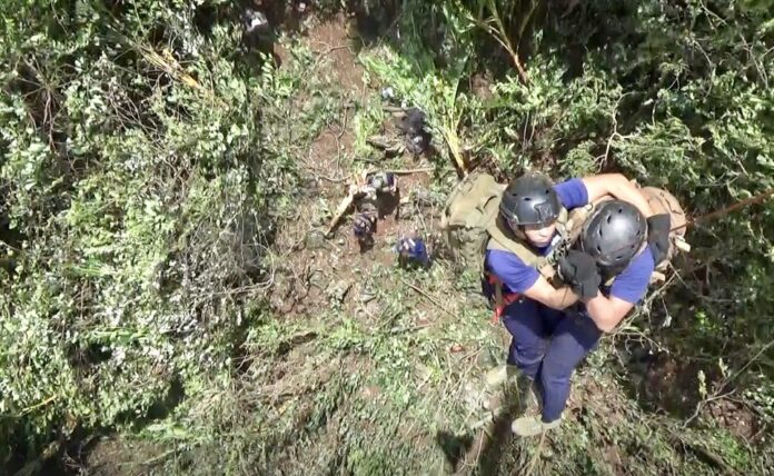 Border patrol police on Friday morning descend by rope from a helicopter onto a hill above the cave. Border patrol police on Friday morning descend by rope from a helicopter onto a hill above the cave.