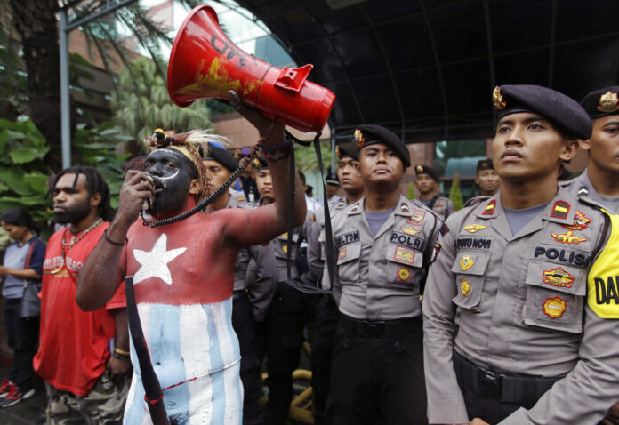 A Papuan activist whose body is painted in the colors of