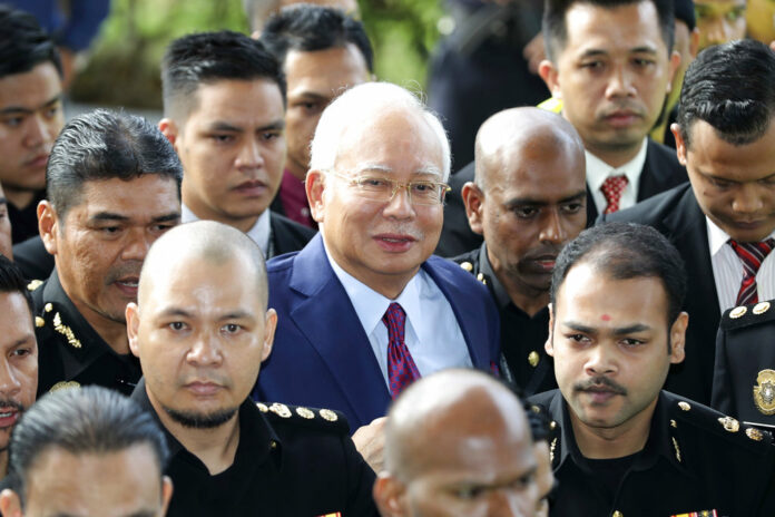 Former Malaysian Prime Minister Najib Razak, center, arrives at a court house Wednesday in Kuala Lumpur, Malaysia. Photo: Vincent Thian / Associated Press