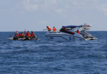 Thais Work to Salvage Sunken Boat; Search on for 14 Missing Thai rescue divers and a tourist police boat are seen Saturday during a search mission for missing passengers from a capsized tourist boat in the water off Phuket. Photo: Vincent Thian / Associated Press
