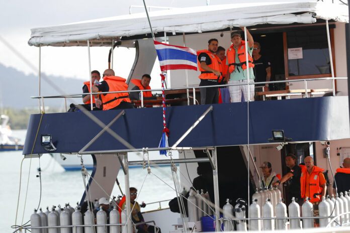 Tourists look out from a tour boat July 8 at Chalong pier in Phuket. Photo: Vincent Thian / Associated Press
