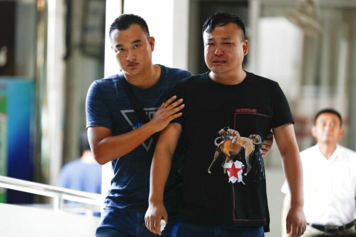A Chinese relative of a victim in the Phoenix boat sinking is consoled Saturday at the Vachira Phuket Hospital on Phuket. Photo/Vincent Thian / Associated Press