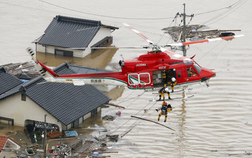A resident is rescued in a flooded area Saturday in Kurashiki, Japan, following heavy rains. Photo: Shohei Miyano / Associated Press