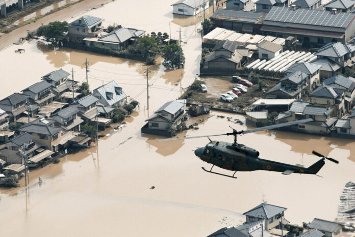 A helicopter flies Monday over a flooded housing area in Kurashiki, Okayama prefecture, western Japan. Photo: Associated Press