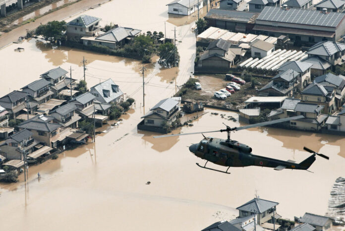 A helicopter flies Monday over a flooded housing area in Kurashiki, Okayama prefecture, western Japan. Photo: Associated Press A helicopter flies Monday over a flooded housing area in Kurashiki, Okayama prefecture, western Japan. Photo: Associated Press
