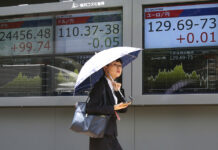 Asian Markets Rise on China-US Trade Prospect A woman walks by an electronic stock board of a securities firm in July in Tokyo, Japan. Photo: Koji Sasahara / Associated Press