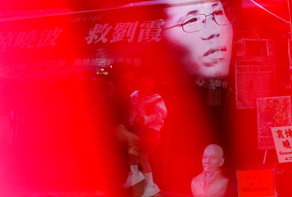 An image of Liu Xia, wife of the late Nobel Peace Laureate Liu Xiaobo, is displayed at a booth to collect signatures from the public in releasing of her at a down town street Tuesday in Hong Kong. Photo: Vincent Yu / Associated Press