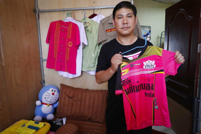 Banphot Konkum, father of Duangpetch Promthep, one of the rescued Thai boys, shows his son's soccer jersey during an interview at their home in Mae Sai district, Chiang Rai. Photo: Vincent Thian / Associated Press