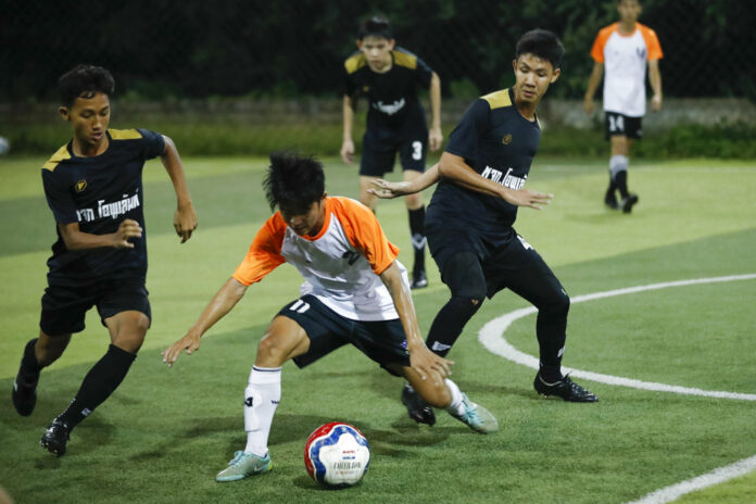 The Wild Boars football team, in black, play a local team during a Mae Sai football league soccer match, July 15, 2018 in Mae Sai district in Chiang Rai province. Photo: Vincent Thian/ Associated Press