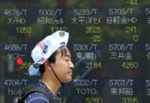 Asian Stocks Rally as Weaker Yuan Eases Fear of More Tariffs A man walks by an electronic stock board of a securities firm in July in Tokyo, Japan. Photo: Koji Sasahara / Associated Press