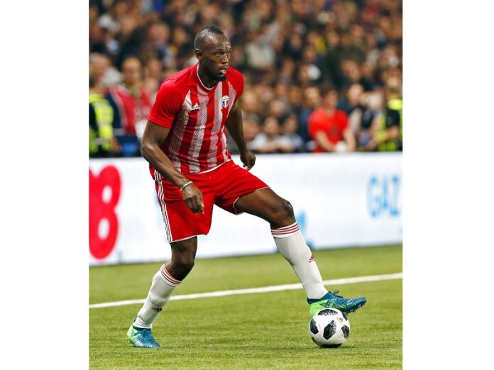 Former Olympic and Jamaican sprinter Usain Bolt controls the ball during a charity soccer match between members of the 1998 World Cup winning French team and a team of international veteran players who were also involved in the same tournament, in June at the U Arena in Nanterre, north of Paris, France. Photo: Thibault Camus / Associated Press