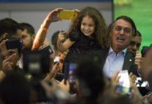 Modern Media Magnify Impact of Assassinations Presidential candidate Jair Bolsonaro holds a little girl as he poses for photos with supporters during the National Social Liberal Party convention where he accepted the party's nomination in July in Rio de Janeiro, Brazil. Photo: Leo Correa / Associated Press