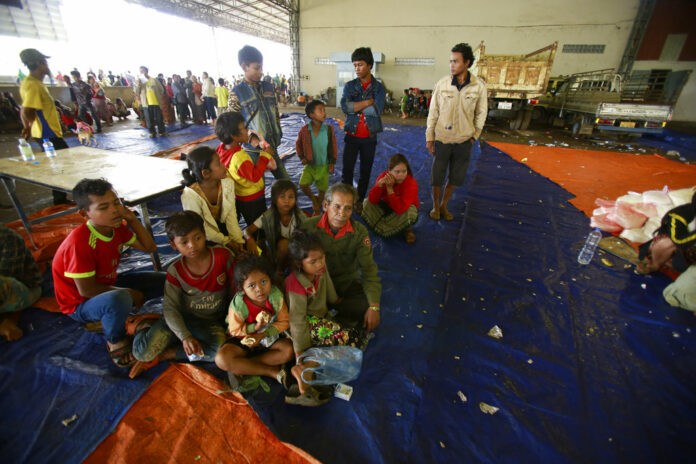 Villager Phon Vuongchonpu and his grandchildren take refuge at a shelter Wednesday in Paksong town, Champasak province, Laos. Photo: Hau Dinh / Associated Press