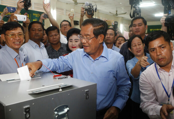 Cambodian Prime Minister Hun Sen, center, of the Cambodian People's Party casts his ballot in the country's general election Sunday at a polling station in Takhmua in Kandal province, southeast of Phnom Penh, Cambodia. Photo: Heng Sinith / Associated Press