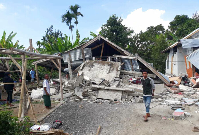 Villagers walk near destroyed homes in an area affected by the early Sunday morning earthquake at Sajang village, Sembalun, East Lombok, Indonesia. Photo: Rosidin / Associated Press