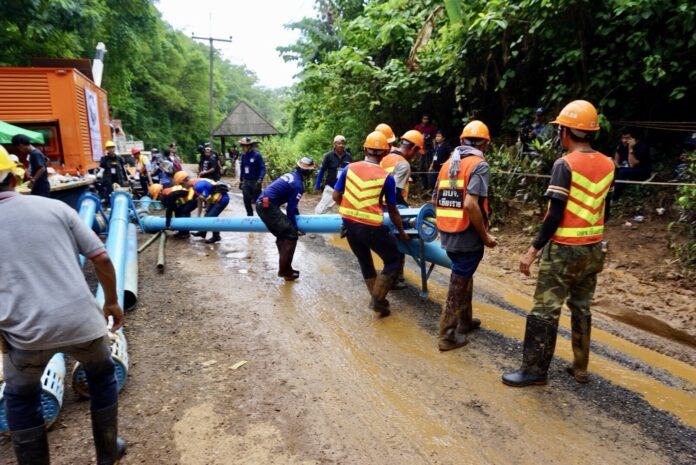 Rescue workers move pipes used to pump water from the cave.
