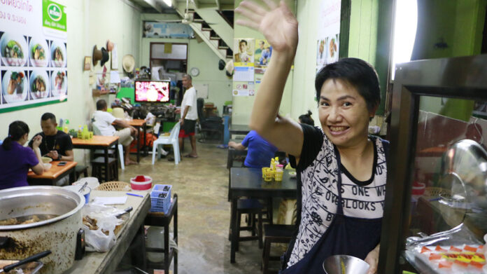 Kanyarat “J’Tae” Wongwattanachai waves while serving free noodles at Koto Guay Tiew shop.