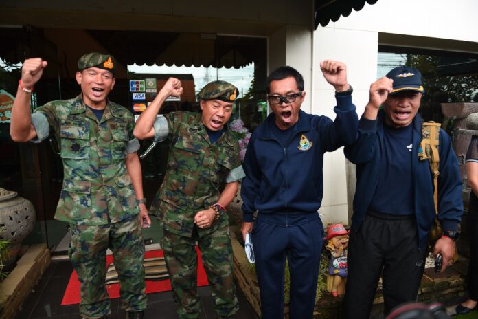 Thai SEAL commander Apakorn Yookongkae, second from left, shouts with his officers Thursday before returning to their Chonburi headquarters after completing their rescue mission.