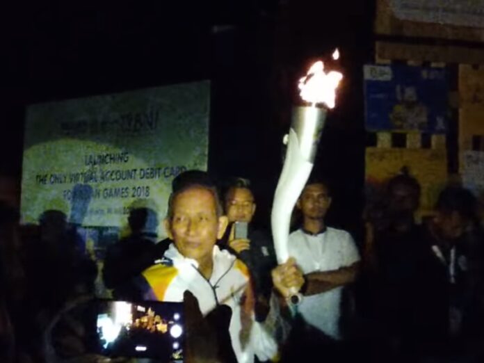 Torch ambassador Yustedjo Tarik holds the torch of the Asia Games on Wednesday in Yogyakarta, Indonesia. Photo: ahmad jayadi / YouTube