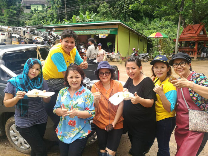 Volunteer cooks serve food from the back of a pickup truck down the hill from where an army of rescuers and volunteers had worked to free 13 people trapped in a flooded cave.