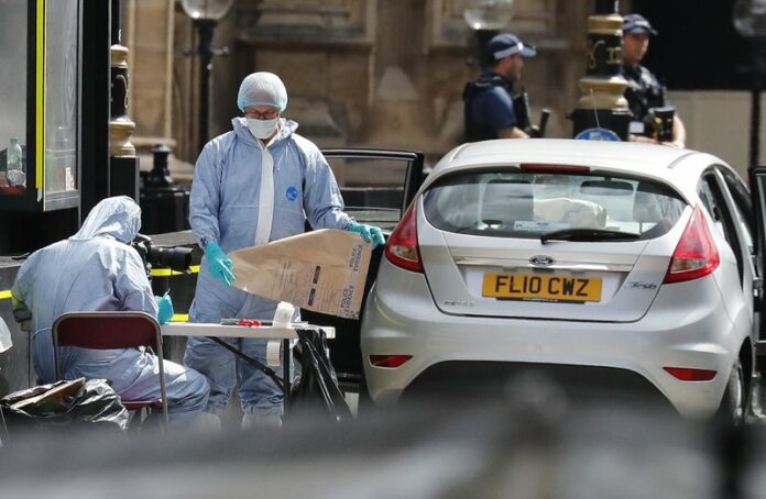 Forensic police investigate the scene of the car crash outside the UK Parliament in London on Tuesday. (AP Photo)