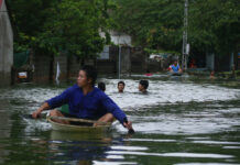 Landslides Kill 13, Leave 4 Missing in South Central Vietnam A man paddles a boat and others swim through flooded villageon July 31, 2018 in Chuong My district, Hanoi, Vietnam. Photo: Manh Thang/ Associated Press File