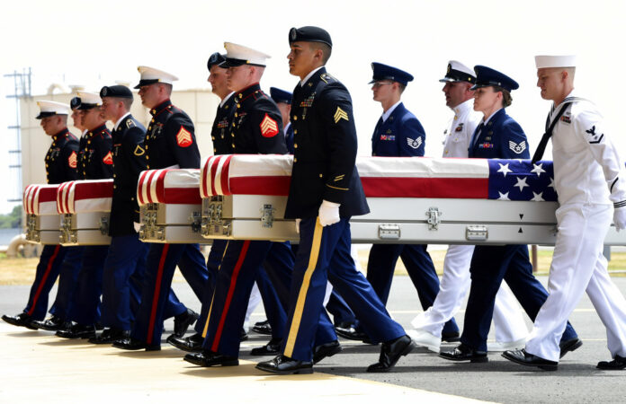 Military members carry transfer cases from a C-17 at a Wednesday ceremony marking the arrival of the remains believed to be of American service members who fell in the Korean War at Joint Base Pearl Harbor-Hickam in Hawaii. Photo: Susan Walsh / Associated Press