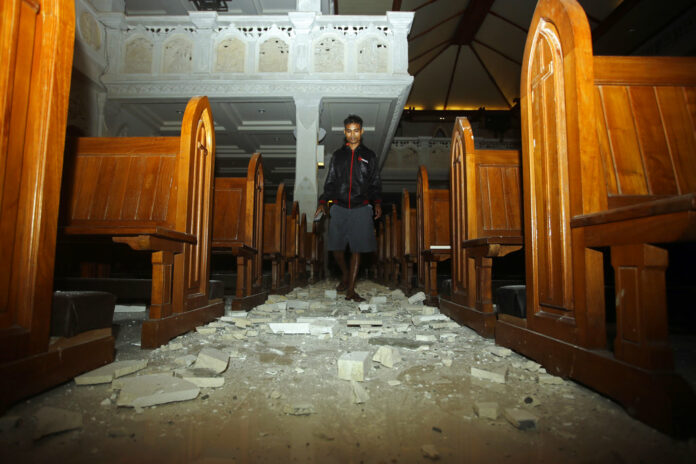 A man walks inside a cathedral Sunday where debris has fallen after an earthquake in Bali, Indonesia. Photo: Firdia Lisnawati / Associated Press