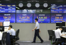 Asian Stocks Rise After Solid US Jobs Report A currency trader walks by screens showing foreign exchange rates at the foreign exchange dealing room of the KEB Hana Bank headquarters Monday in Seoul, South Korea. Photo: Ahn Young-joon / Associated Press