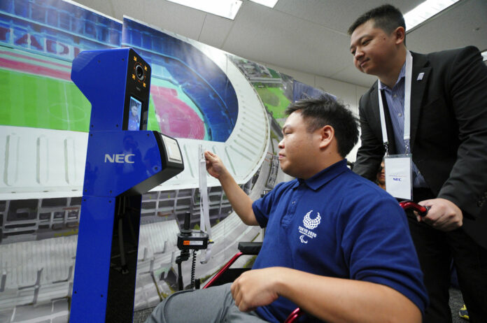 A staff member demonstrates a new face recognition system used for the Tokyo 2020 Olympic and Paralympic Games during a press conference in Tokyo Tuesday, Aug. 7, 2018. Photo: Eugene Hoshiko/ Associated Press
