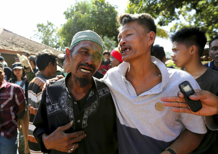 Relatives react as rescue teams recover the bodies of victims killed in an earthquake in North Lombok, Indonesia, Tuesday, Aug. 7, 2018. Photo: Tatan Syuflana / Associated Press