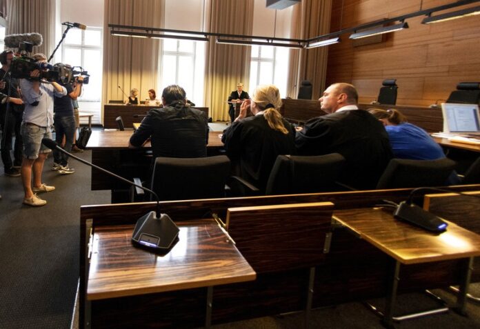 Photographers take pictures of the a man and a woman in the court Tuesday in Freiburg, southern Germany. Photo: Patrick Seeger / Associated Press