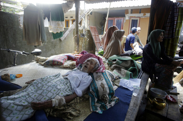 An elderly man injured in an earthquake lies at a temporary shelter Wednesday in the Kekait village affected by Sunday's earthquake in North Lombok, Indonesia. Photo: Firdia Lisnawati / Associated Press