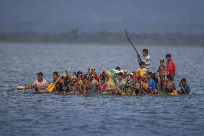 Rohingya Muslims aboard a makeshift raft made with plastic containers cross over the Naf river from Myanmar into Bangladesh, nearin 2017 in Shah Porir Dwip, Bangladesh. Photo: A.M. Ahad / Associated Press