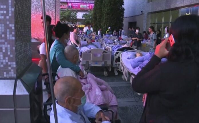 In this image from a video, patients stay outside of Taipei Hospital of the Ministry of Health and Welfare in New Taipei City, Taiwan following a fire Monday, Aug. 13, 2018. Photo: EBC via Associated Press