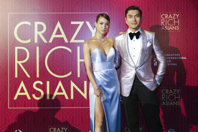 Actor Henry Golding and his wife Liv Lo pose as they arrive for the red carpet screening of the movie 
