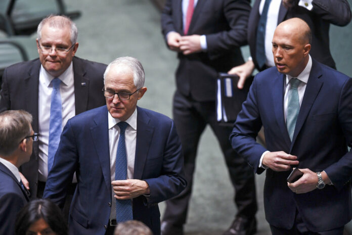 Australian Federal Treasurer Scott Morrison, second left, Prime Minister Malcolm Turnbull, center, and former Home Affairs Minister Peter Dutton, right, leave the chamber at Parliament House in August in Canberra. Photo: Lukas Coch / Associated Press